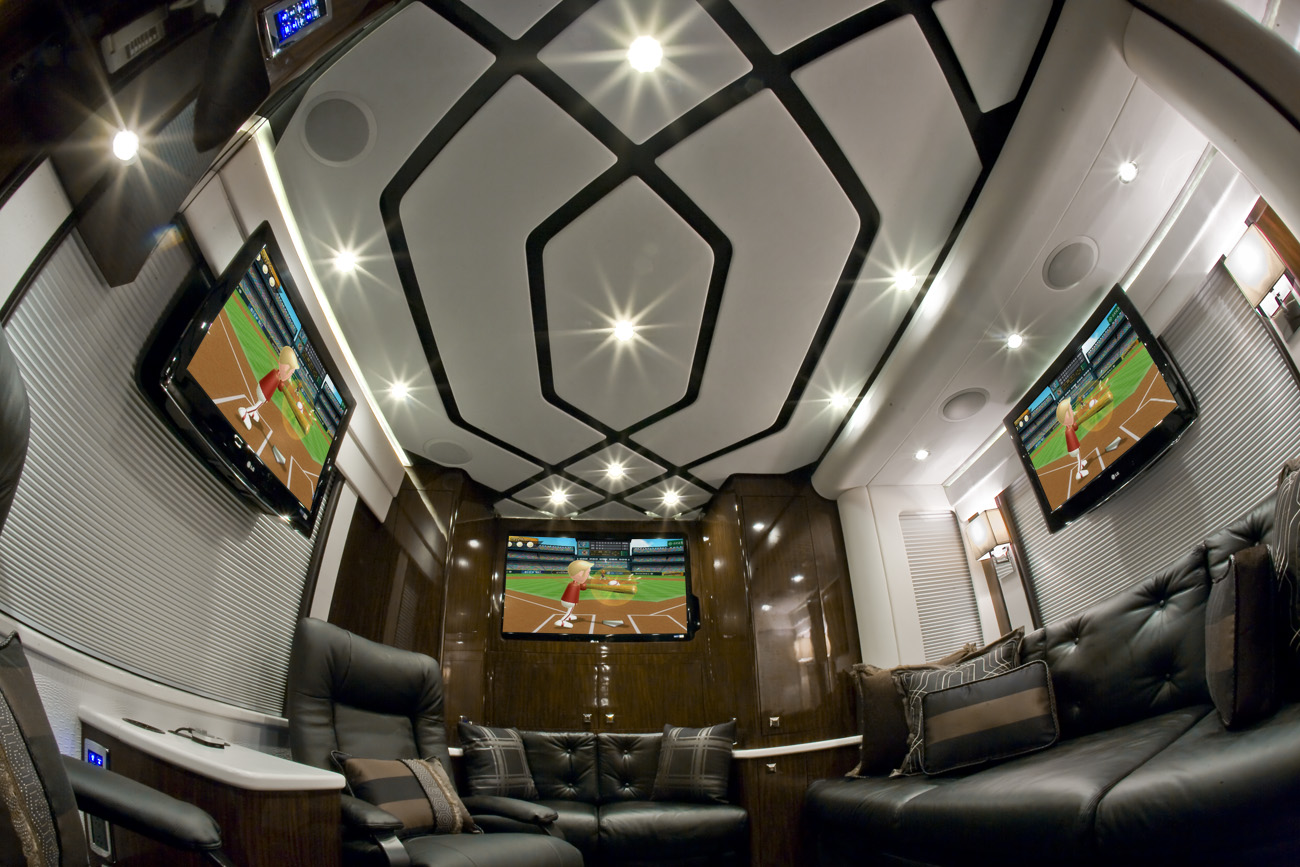 a room with three TV screens and black couch